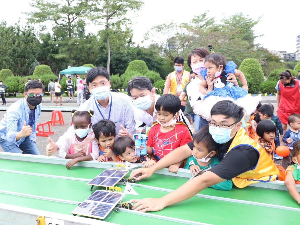 The competition sponsor, Kuo, Pao-Lang (郭寶朗), a manager of Bridgestone Taiwan Co., Ltd., Professor Ay, and the competition staff took time to teach kids how to play with solar cars.