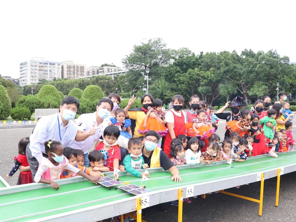The competition sponsor, Kuo, Pao-Lang (郭寶朗), a manager of Bridgestone Taiwan Co., Ltd., Professor Ay, and the competition staff took time to teach kids how to play with solar cars.