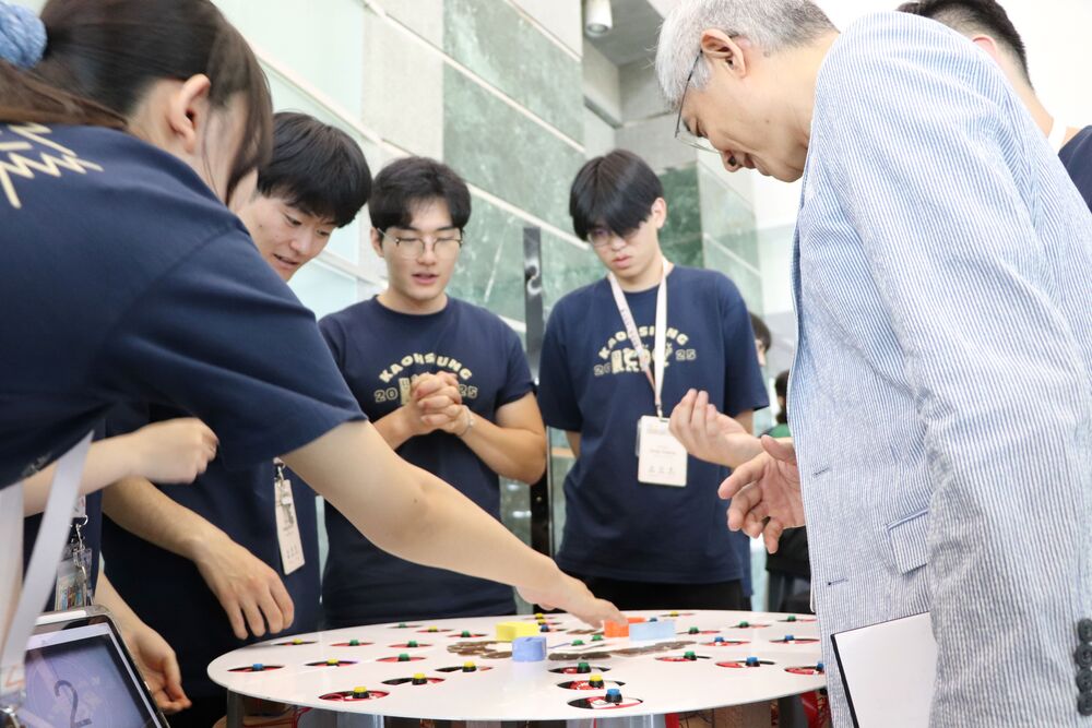 Hsueh Po-wen, Dean of the Office of Innovation and Entrepreneurship at NKUST, stated that ICDC teams are consistently formed by mixing students from the three universities. The students' majors are diverse, and most projects combine software and hardware such as programming, circuitry, and structural design. Pictured is the project from the "I CAN Defence Cosmos" team, which is similar to a whack-a-mole game where mechanisms on a circular plate light up randomly, and players must press buttons to turn off the lights. The circuitry beneath the plate is complex, making its production highly challenging.
